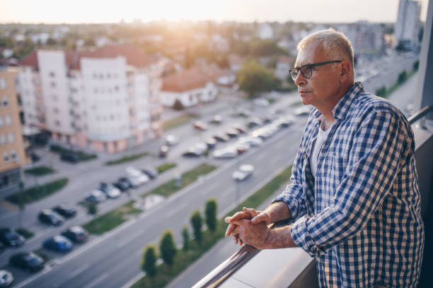 istock Pensive senior man looking at view form his penthouse balcony. 914770560