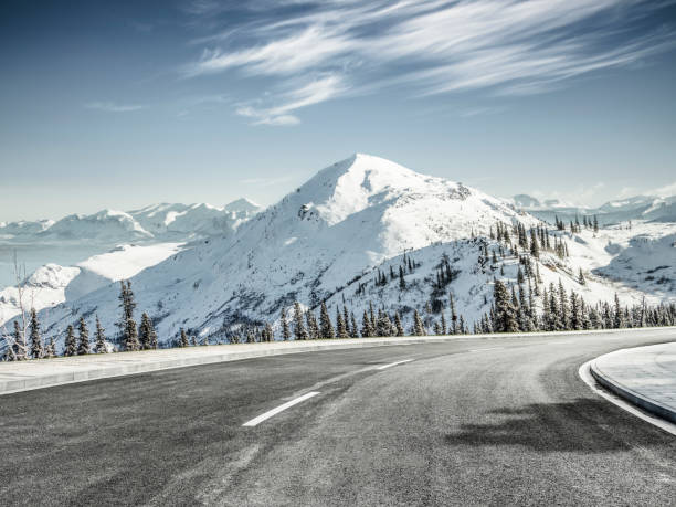 istock empty asphalt road leading towards snow mountains 914771350