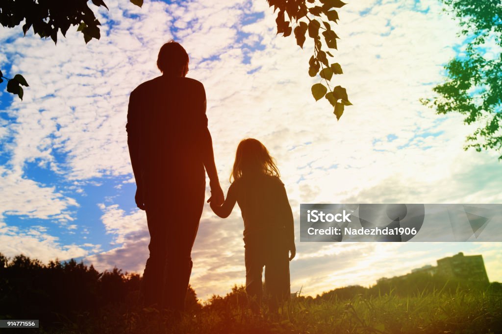 silhouette of father and daughter holding hands at sunset silhouette of father and daughter holding hands at sunset nature Adult Stock Photo