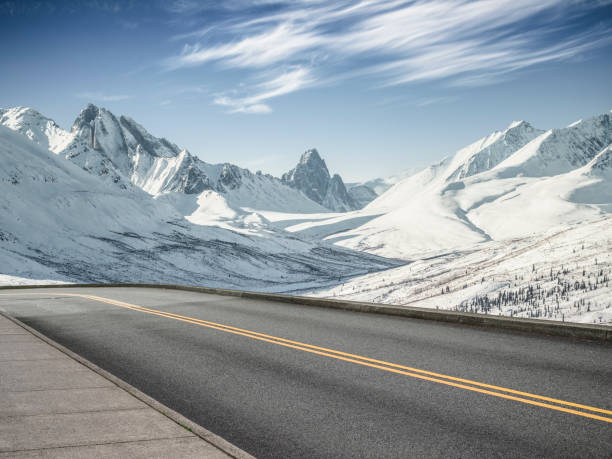 istock empty asphalt road leading towards snow mountains 914772056
