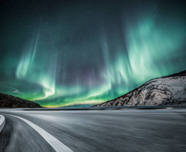 istock aurora borealis over blurred asphalt road in Canada 914775872
