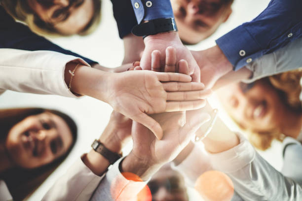We're here to always motivate each other Cropped shot of a group of businesspeople putting their hands together in a huddle loyalty photos stock pictures, royalty-free photos & images