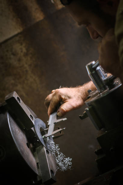 istock Worker professionally measuring the shaped material on lathe 914776056