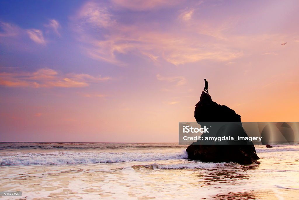 ocean céu pôr do sol e o homem no topo da formação rochosa - Foto de stock de Mar royalty-free