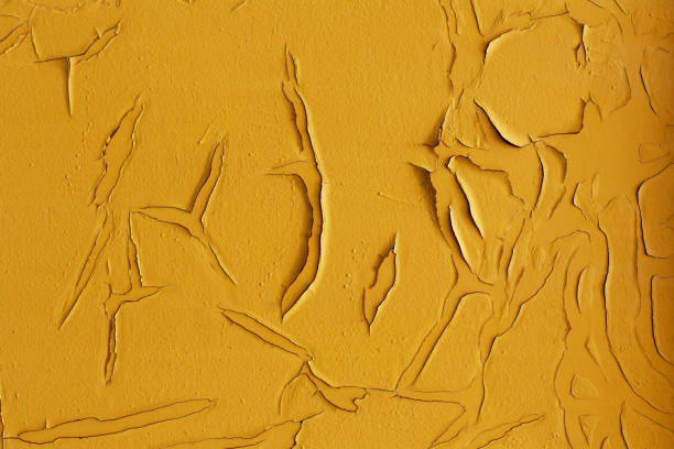 istock Old cracked yellow painted wall closeup 914779834