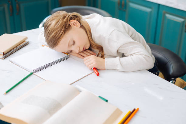 istock Adorable blond girl sleeping over her notebook 914783062