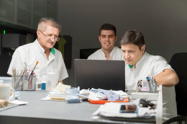 protésicos dentales de laboratorio, mirando portátil - technician dentures prosthetic equipment workshop fotografías e imágenes de stock