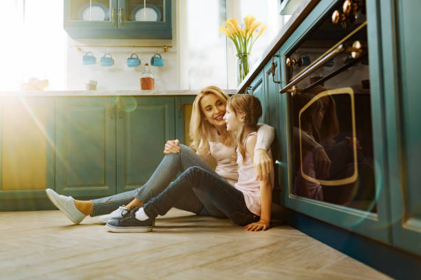 istock Exuberant mother and daughter sitting on the floor 914784784