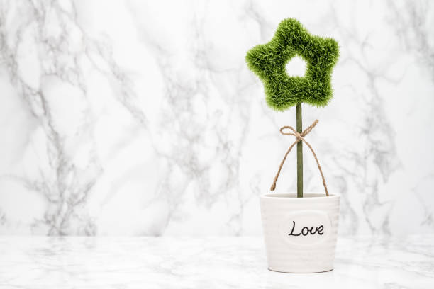 Small decorative artificial green plant in white pot with \