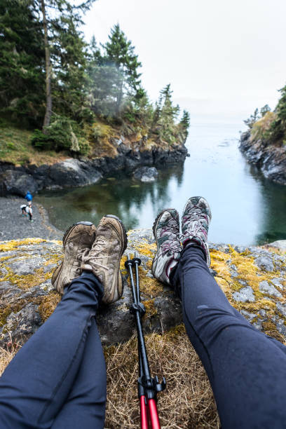 istock Personal Perspective of Two Women Hikers Resting, Viewing Remote Beach 914787618