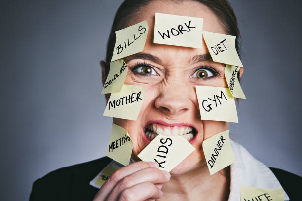 istock Face obscured by task reminders, woman bites one note angrily 914788548