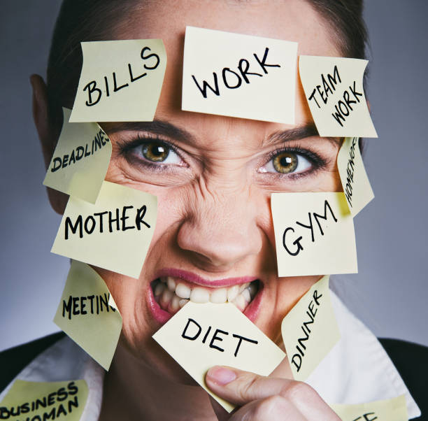 istock Angry woman, overwhelmed by many responsibilities, bites one task reminder 914788840