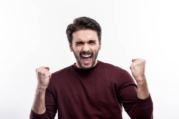 istock Overjoyed young man raising hands in triumph 914789128