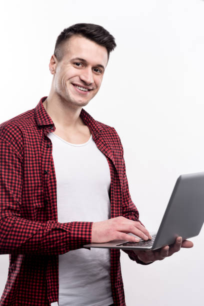 istock Handsome man in checked shirt posing with laptop 914792892