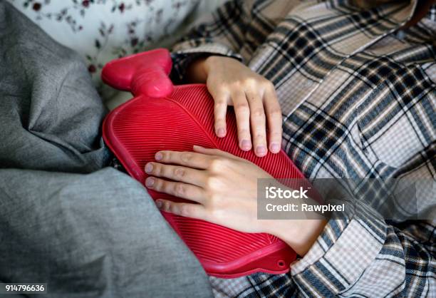 Mujer Caucásica De Tener Período Doloroso Calambres Foto de stock y más banco de imágenes de Bolsa de agua caliente