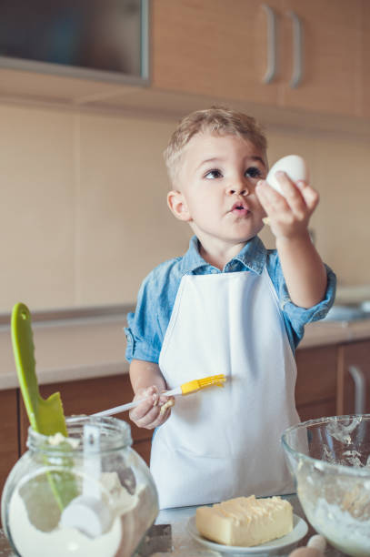 istock adorable boy holding egg and cooking brush 914800084