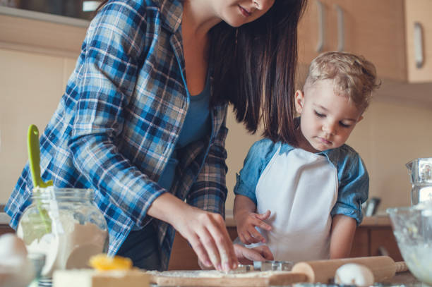 istock cropped image of mother making cookies with dough molds 914800444