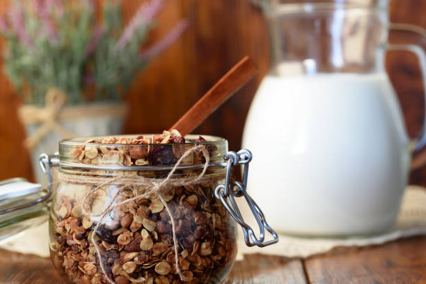 Homemade granola with nuts, cranberries and dried apricots, and a jug of milk. selective focus, copy space