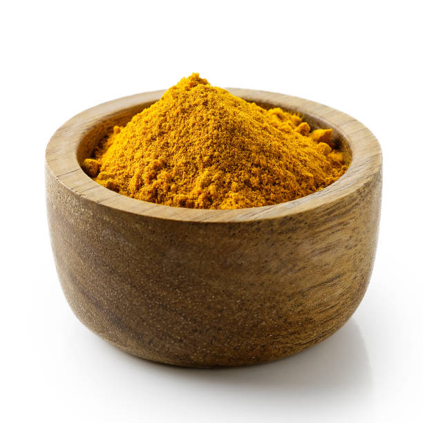 istock Turmeric powder in dark wood bowl isolated on white. 914803328