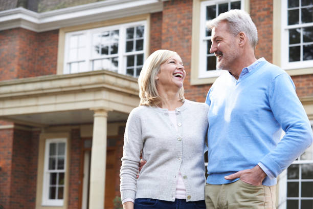 istock Smiling Mature Couple Standing Outside Home 914806484