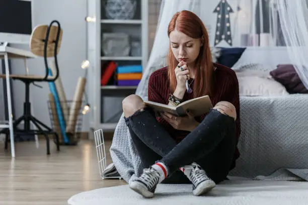 Photo of Girl thinking over notebook