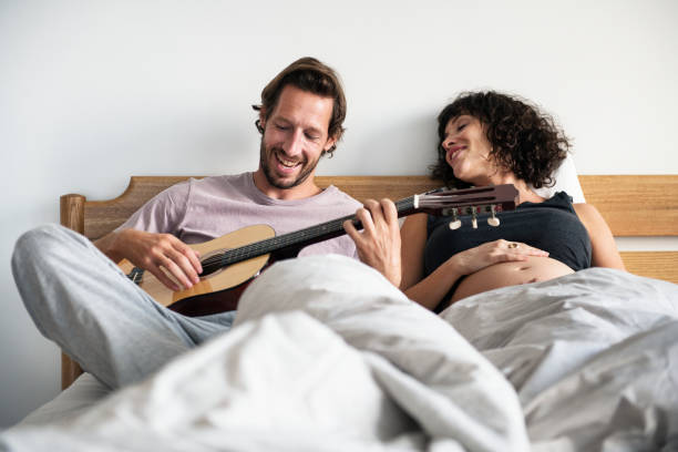 man playing guitar for pregnant wife - 269 imagens e fotografias de stock