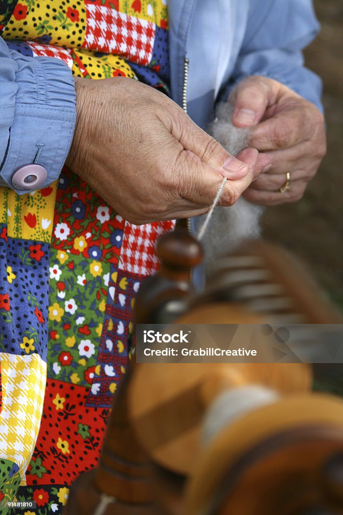 Woman in Colorful Apron Spinning Yarn  Antique Stock Photo