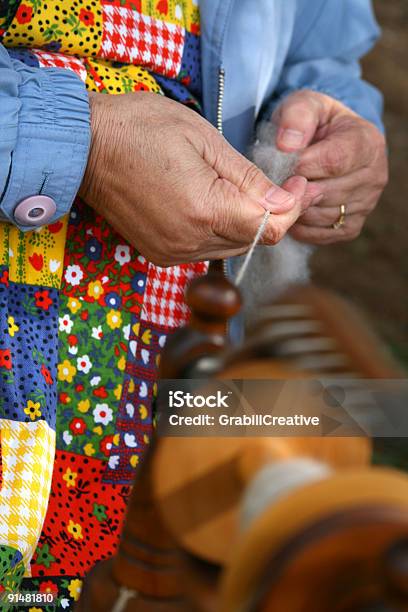 Woman In Colorful Apron Spinning Yarn Stock Photo - Download Image Now - Antique, Apron, Bright