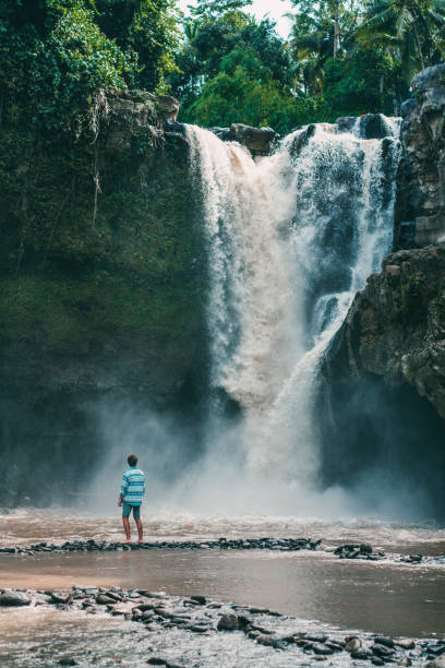 istock Man walking near  Tegenungan waterfall in Bali 914818400