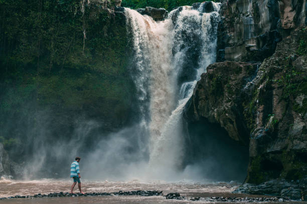istock Man walking near  Tegenungan waterfall in Bali 914818450