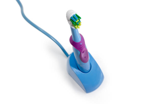 istock Electric toothbrush in charging base closeup at selective focus 914818596