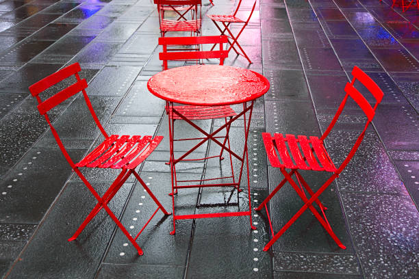 istock City in the Rain: abandoned red chairs and table in wet Times Square 914823326