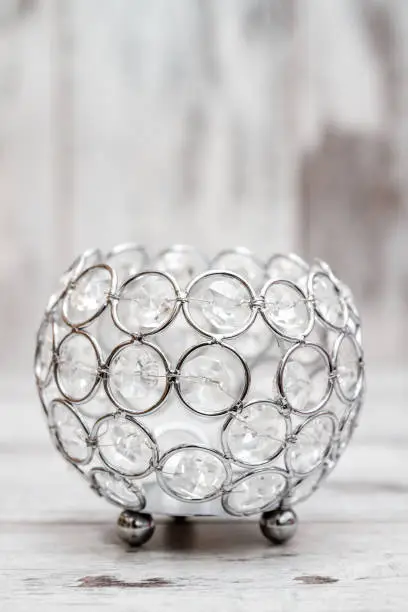Candle holder with crystals on white wooden background