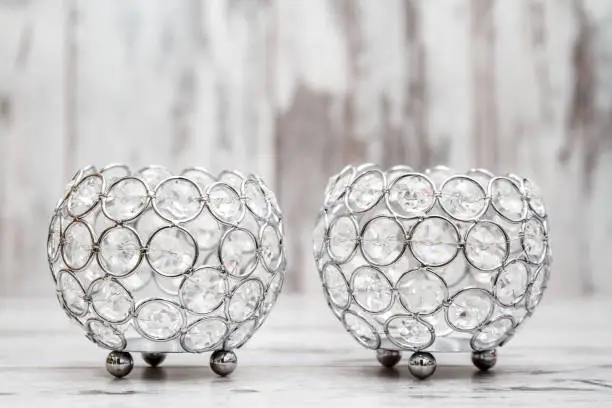 Candle holders with crystals on white wooden background