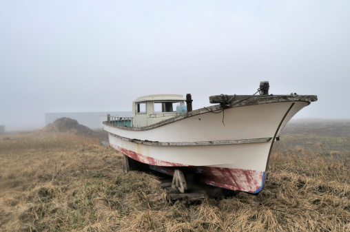 A well worn fishing boat dry docked on island tundra on St Paul Island. I just found the graceful lines of this boat attractive, it just looks like it wants to be in the water.