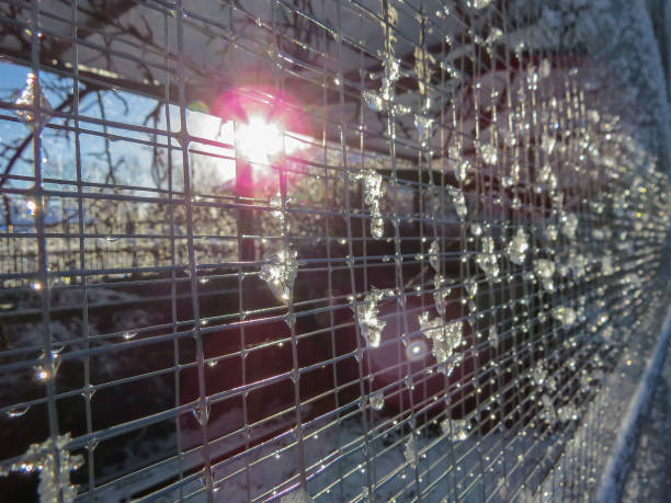 Melting snow on weld mesh. Sun flare light effects.