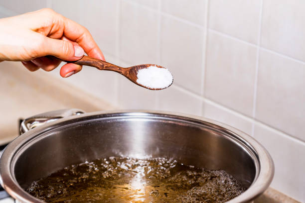 �スープを調理水を沸騰追加塩 - 塩をふる ストックフォトと画像