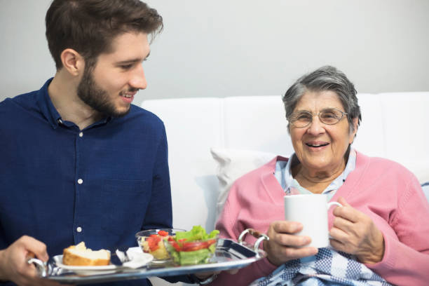 helping to the elderly - senior adult nursing home eating home interior imagens e fotografias de stock