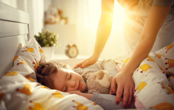 母が朝子娘女の子を寝てを目覚める - wake up ストックフォトと画像