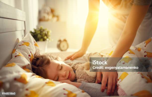 Mother Wakes Up Sleeping Child Daughter Girl In Morning Stock Photo - Download Image Now