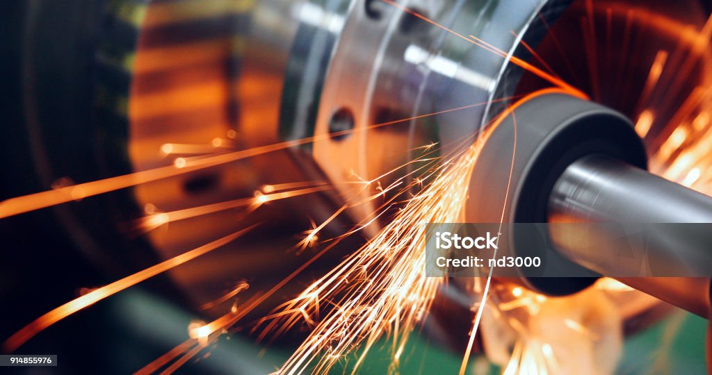 sparks flying while machine griding and finishing metal sparks flying while machine griding and finishing metal in factory Manufacturing Stock Photo