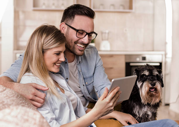 jeune couple avec chien regardant tablet - digital tablet women enjoyment happiness photos et images de collection