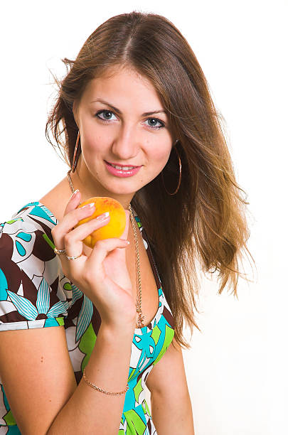 The young girl with a peach stock photo