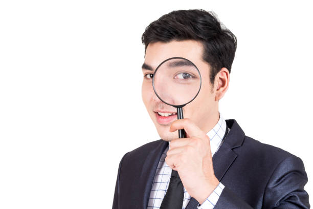 istock Businessman holding magnifying glass isolated on white background 914859770