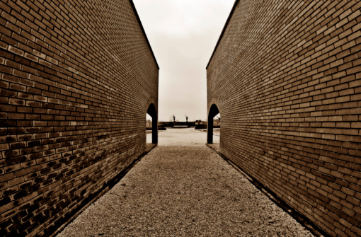 Between two brick walls in the open air Memento Park in Hungary. Many statues of the socialism were removed from their original place during the political transition in Hungary in 1990 and moved to this place. Fisheye lens used.