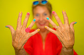 Color Surge for Stylish Seniors - happy senior woman showing her colorful fingernails