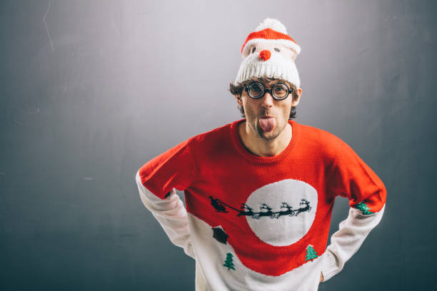 彼の舌を突き出て面白いクリスマスの服で不機嫌そうな男 - rudeness ugliness clothing people ストックフォトと画像