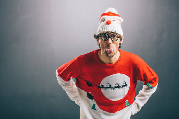 moody man in funny christmas clothes sticking out his tongue - rudeness ugliness clothing people imagens e fotografias de stock