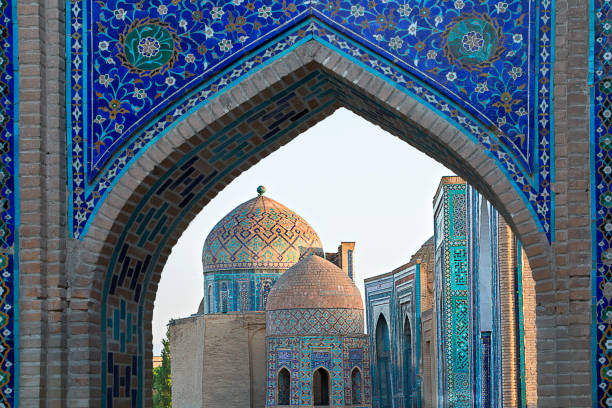 View over the mausoleums and domes of the historical cemetery of Shahi Zinda through an arched gate, Samarkand, Uzbekistan. Historical cemetery of Shahi Zinda, Samarkand, Uzbekistan khiva stock pictures, royalty-free photos & images