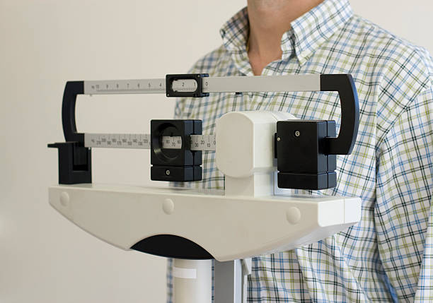 istock man on medical  weight scale 91486832